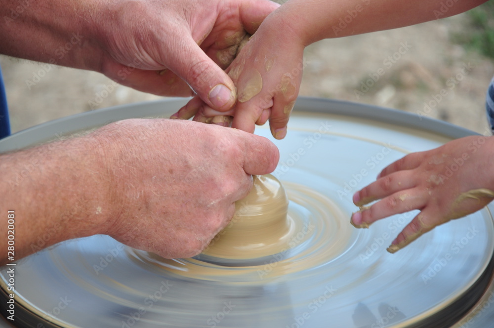 Potter's wheel and people working with it Potter's wheel and people working with it