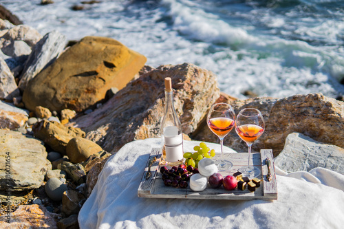 Beach sea scene summer picnic with rose wine and grapes, marshmallow, berries. Concept for wallpaper, print idea, celebration, blog. Vacation farmhouse tourism concept with natural food