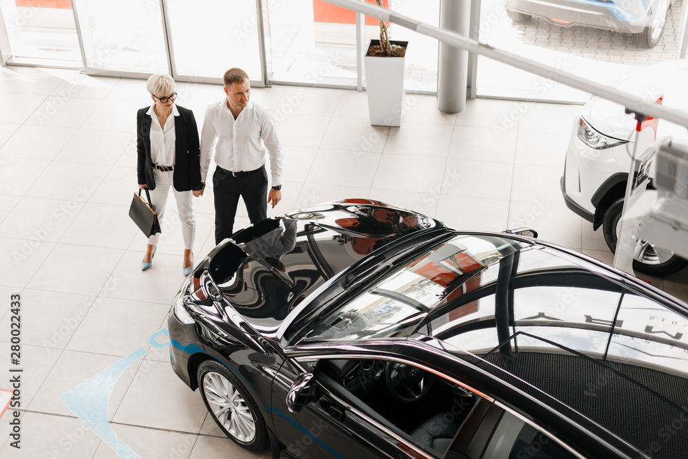 Φωτογραφία Wife and husband couple in dealership choose a car. Top view