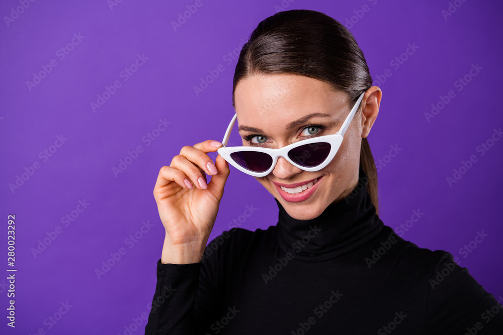 Close up photo of nice pretty millennial touching her specs looking smiling wearing black turtleneck isolated over purple violet background Close up photo of nice pretty millennial touching her specs looking smiling wearing black turtleneck isolated over purple violet background