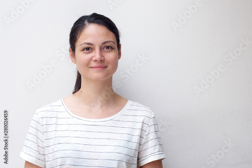 horizontal portrait of attractive young asian woman smiling by white background © mimagephotos