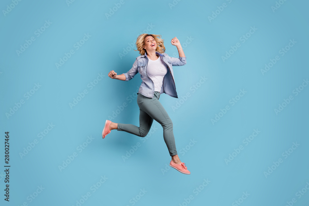 Full length photo of lovely charming person raising arms laughing wearing pants trousers isolated over blue background - obrazy, fototapety, plakaty 