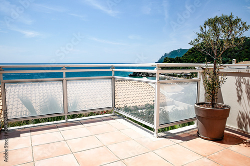 A balcony on a sunny blue sky and ocean view on a summer day. © magdal3na