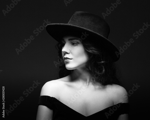 Profile portrait of a beautiful lady wearing a black hat