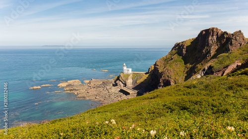 The lighthouse of Hartland Point in the English county of Devon. A view in the sunshine and blue sky of the sea, the bay and the mountain. photo