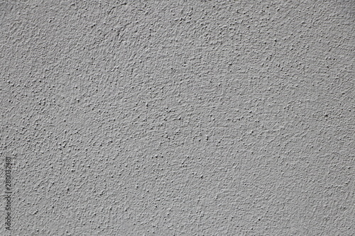 Texture of an evenly plastered grey stonewall, background with copy space