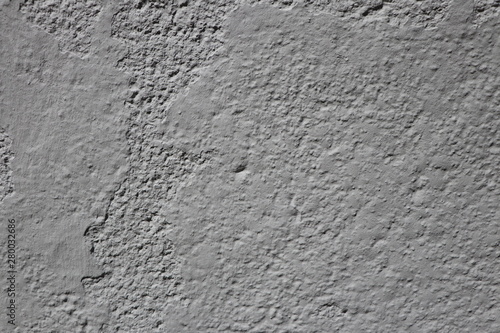 Texture of a roughly plastered gray stonewall, background with copy space