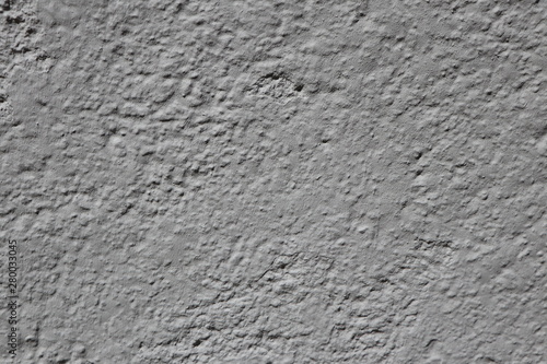Texture of an unevenly plastered grey stonewall, background with copy space