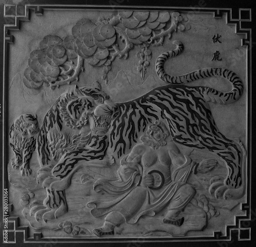Stone carving of a tiger fighting a Chinese warrior