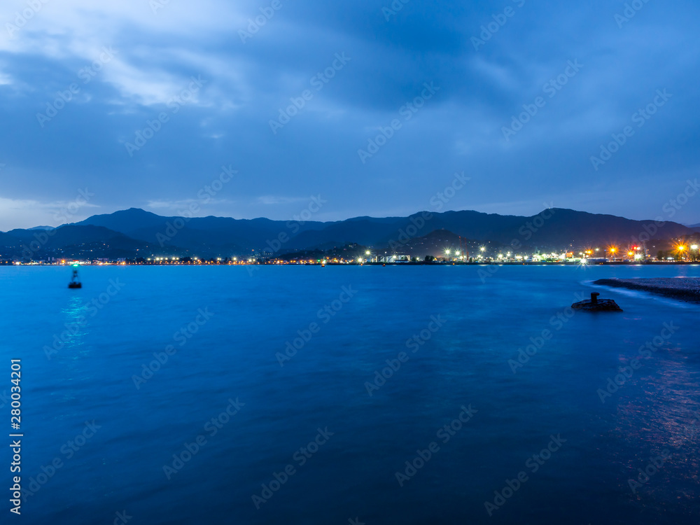 Obraz premium Distant lights and structures of Batumi port early in the morning