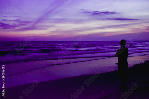 Silhouette of people on great sunset with beautiful view of sea and beach at twilight.