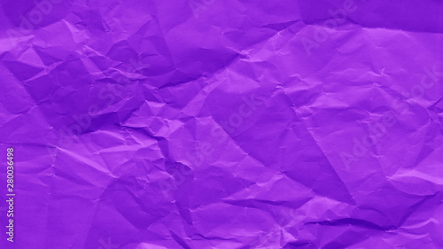 Crumpled sheet of purple color paper texture background