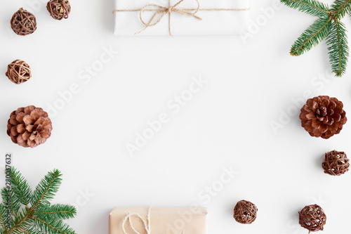 Christmas gifts with pine cones and leaves on a white table. Flat lay with blank copy space.
