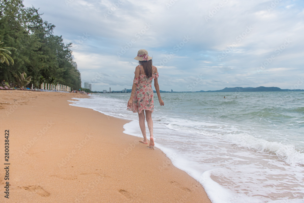 Summer beach vacation concept, Happy young Asian woman with hat walking and relaxing on sand beach with happiness. Summer beach vacation concept, Happy young Asian woman with hat walking and relaxing on sand beach with happiness.