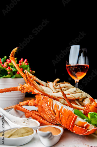 Fabulous lobster dish on wooden table with wine and all the finesse of a luxury restaurant.