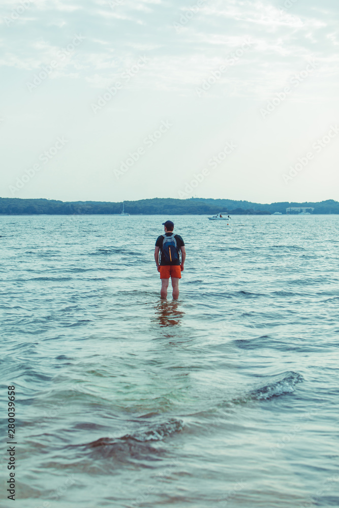 man standing in the sea water at beach