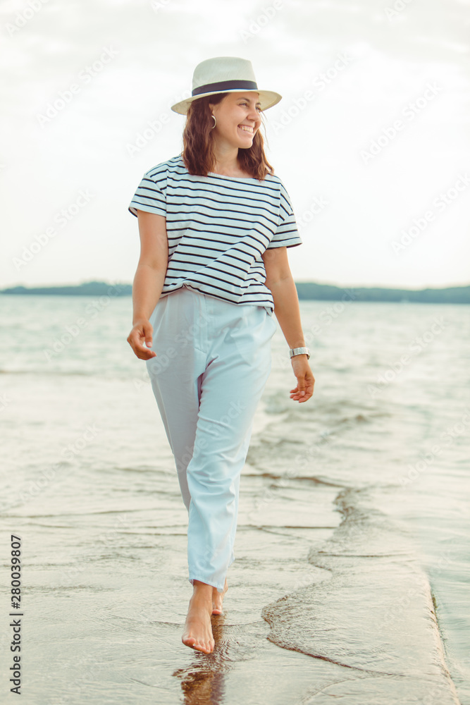 woman in white clothes walking by sea beach