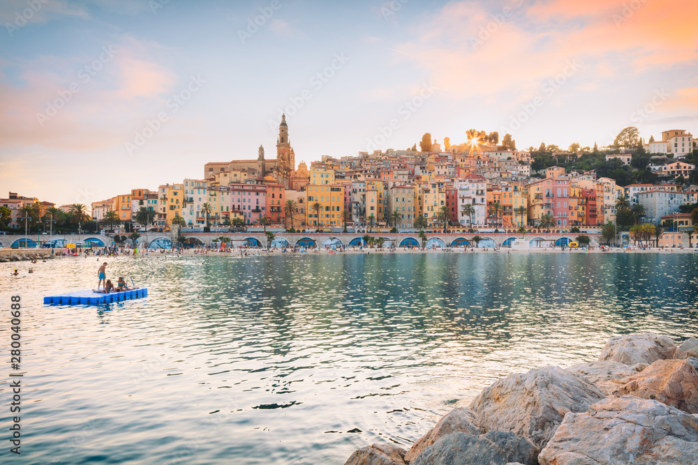 Public beach of Menton old town at sunset