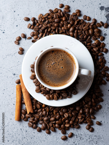 Close-up of white espresso coffee Cup , scattered roasted coffee beans and cinnamon © pavelkant