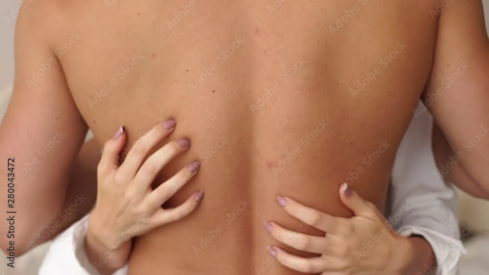 Close-up of a girl passionately embracing her boyfriend behind his naked back, a young couple having sex. Close-up of the girl's hands on the man's back. Sexual relations between a man and a woman. Close-up of a girl passionately embracing her boyfriend behind his naked back, a young couple having sex. Close-up of the girl's hands on the man's back. Sexual relations between a man and a woman.