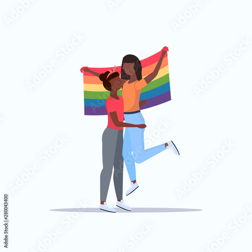 women couple holding rainbow flag love parade lgbt pride festival concept african american lesbians embracing female cartoon characters standing together full length flat