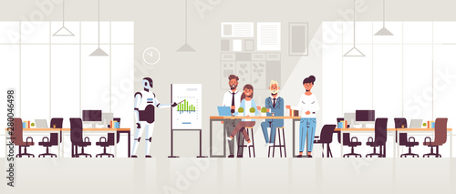 business robot presenting financial graph on flip chart to businesspeople team at conference meeting artificial intelligence technology concept modern office interior full length horizontal