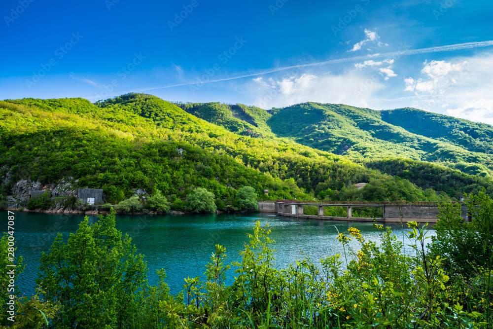 Montenegro, Barrier lake water and dam of jezero liverovoci inside green valley surrounded by green trees and forest near niksic city