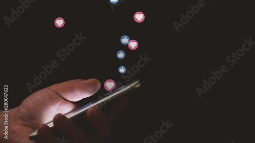 Social Media Concept Close Up of Hand Scrolling Smartphone Screen with Animated Flying Social Media Like Icons photo