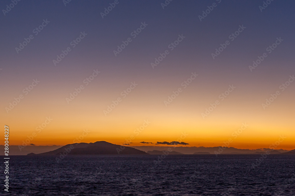 Dreamlike sunset with islands of the Aegean Sea at horizon