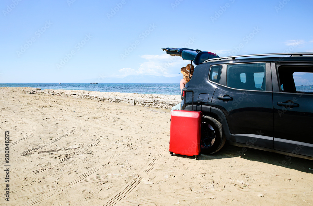 A woman weraing sunglasses and a hat in the summer car on the beach and ocean view.. A woman weraing sunglasses and a hat in the summer car on the beach and ocean view..