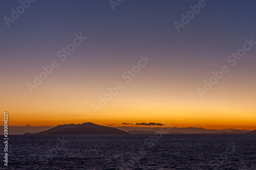 Dreamlike sunset with islands of the Aegean Sea at horizon
