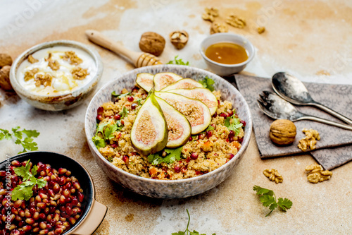 close-up view of tasty healthy couscous salat with figs fruits, nuts and pomegranate seeds 