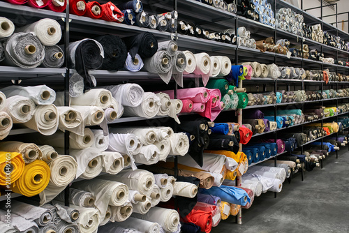 Fabric warehouse with many multicolored textile rolls photo