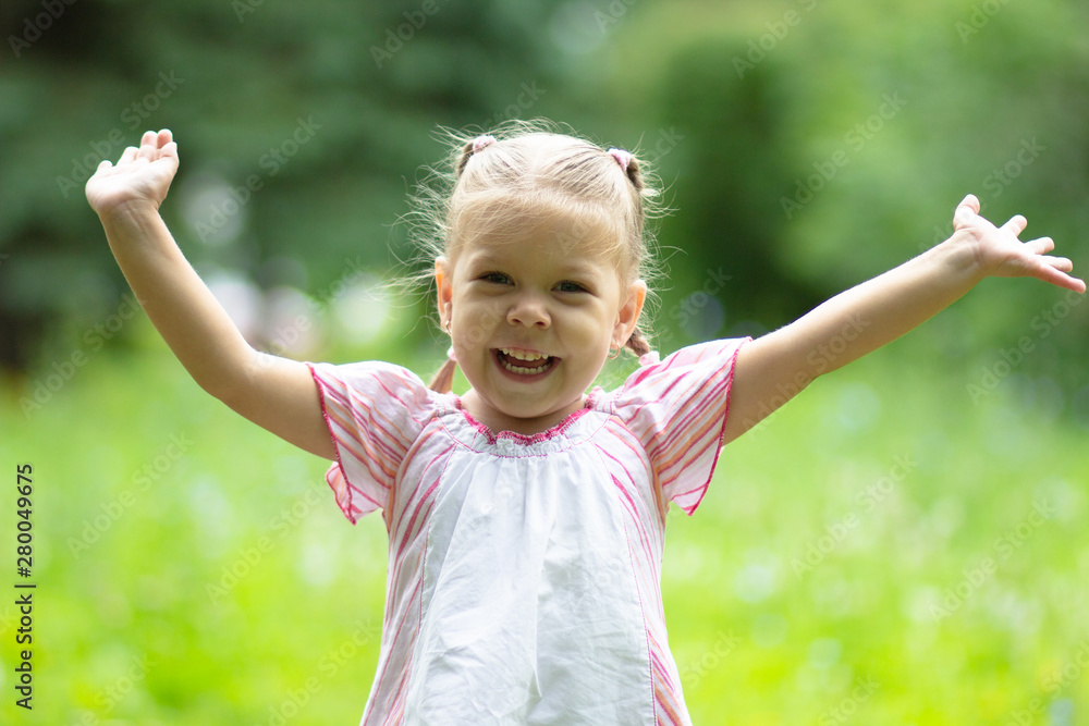 Happy joyful little girl playing in summer park looking at camera Happy joyful little girl playing in summer park looking at camera