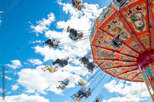 Tampere, Finland - 24 June 2019: Ride Swing Carousel in motion in amusement park Sarkanniemi on blue sky background photo