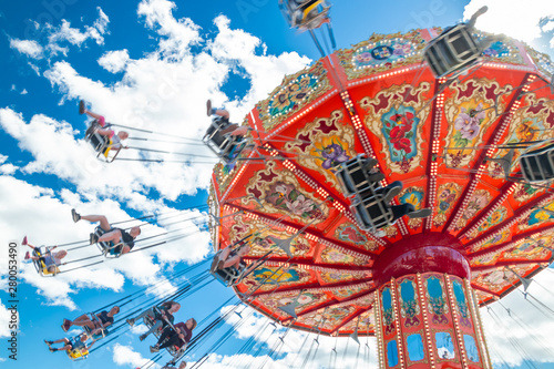 Tampere, Finland - 24 June 2019: Ride Swing Carousel in motion in amusement park Sarkanniemi on blue sky background photo