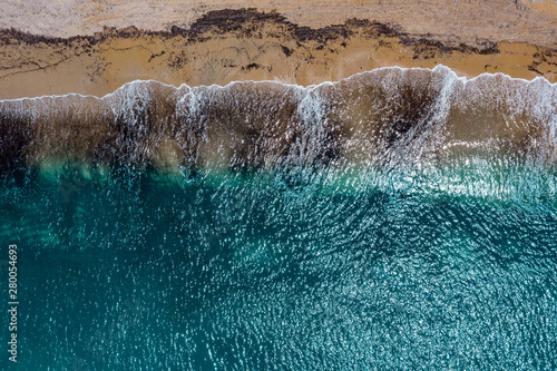 Aerial view of sandy coastline with crystal sea water