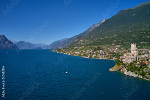 Aerial photography with drone, on the medieval lakeside castle with a museum of history and paleontology, as well as a panoramic view from the tower. City of Malcesine on Lake Garda, Italy. © Berg