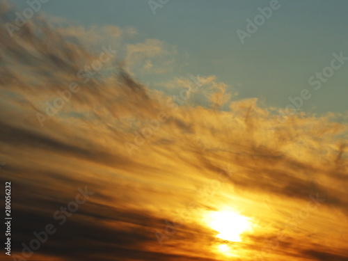 Fototapeta Naklejka Na Ścianę i Meble -  The sun goes down. Beautiful fan of gray clouds. close-up