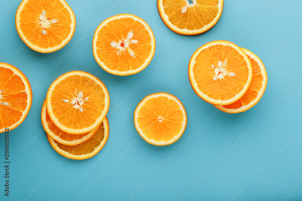 Round slices of juicy orange on a blue background, top view as a background substrate. Food background Round slices of juicy orange on a blue background, top view as a background substrate. Food background
