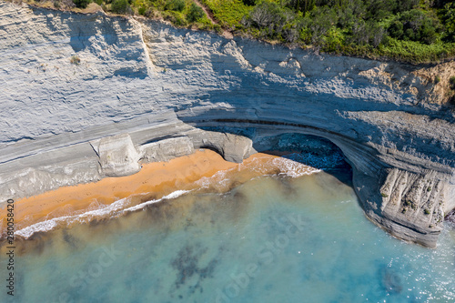 Aerial view of beautiflul rocky cliff and sandy beach by the ocean. photo