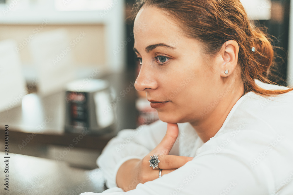 Young attractive girl sitting in cafe and waiting for food or thinking close-up portrait Young attractive girl sitting in cafe and waiting for food or thinking close-up portrait