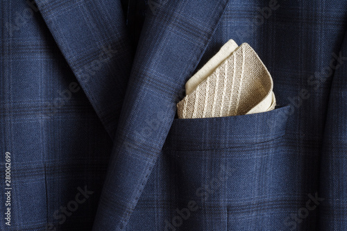 Pocket square with embroidery in the breast pocket of a man's blue suit. Wedding accessories