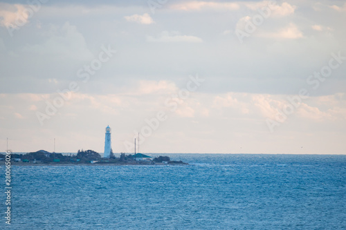 Old lighthouse stands on the sea in the evening