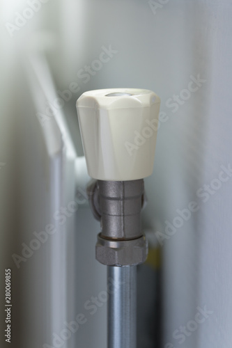 radiator and radiator valve next to a white wall, gas central heating