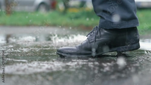 Man in black shoes stepping into the puddle in slow motion 180fps