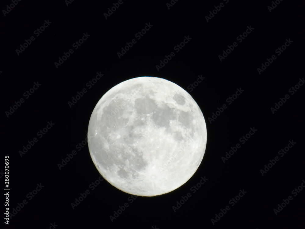 An amazing photography of the full moon over the city of Genova by night with a great clear sky in background and some stars
