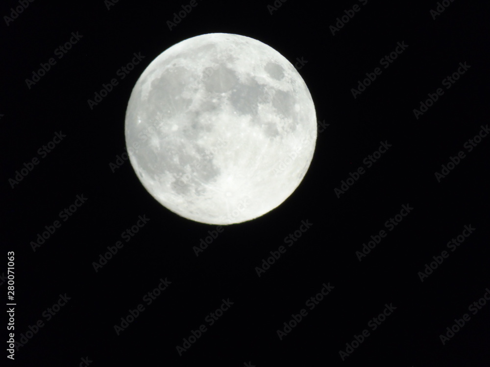 Fototapeta premium An amazing photography of the full moon over the city of Genova by night with a great clear sky in background and some stars