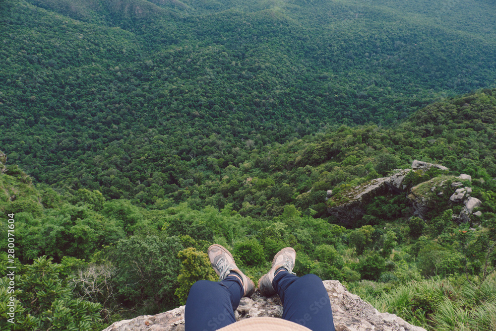 top view of men sitting on cliff against mountain and tree top view of men sitting on cliff against mountain and tree
