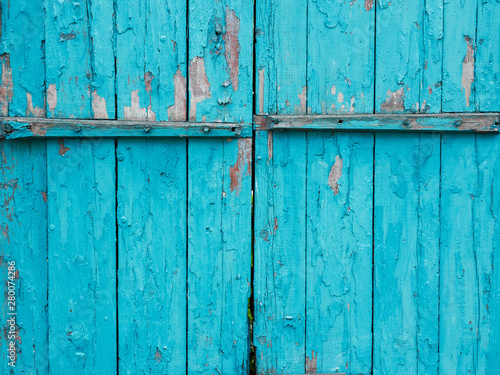 Old turquoise painted wooden doors with peeled faded paint
